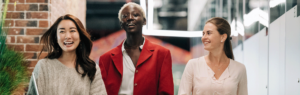 Three women, walking towards the camera, smiling, empowered, strong