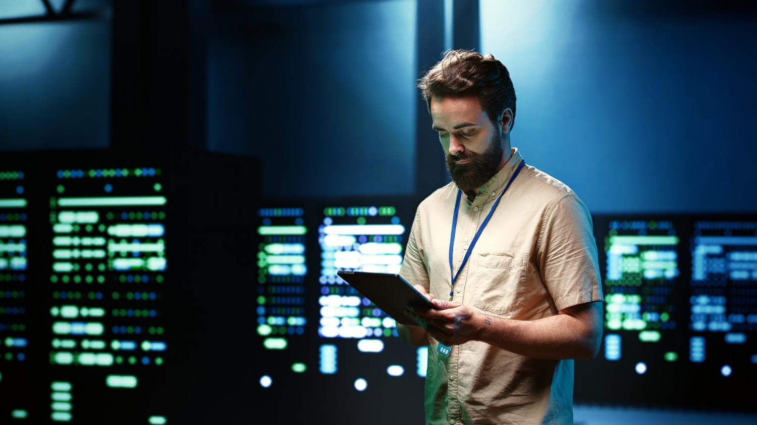 Man standing in a data room looking at a tablet in his hand